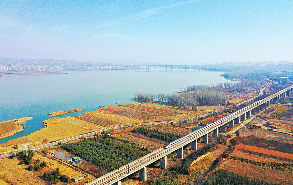 一列动车组列车通过春意渐浓的三门峡沿黄生态廊道